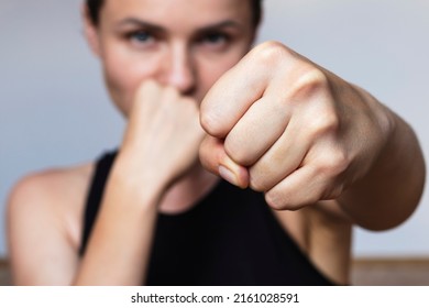 Woman athlete boxing at camera, focus on fist. - Powered by Shutterstock