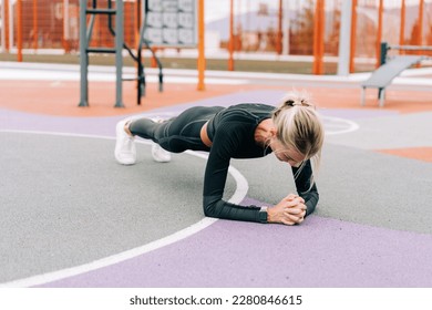 Woman athlete exercising stands in the plank. - Powered by Shutterstock