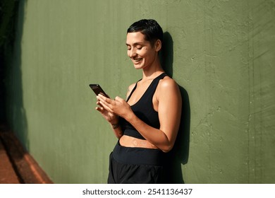 Woman, athlete and outdoor break with phone, basket player and check message on social media. Female person, typing and post score update on internet for followers, training rest and online at court - Powered by Shutterstock