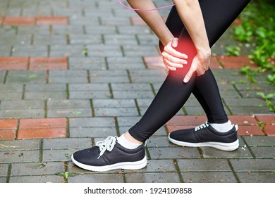 Woman athlete runner touching Knee in pain, fitness woman running in summer park. Healthy lifestyle and sport concept.