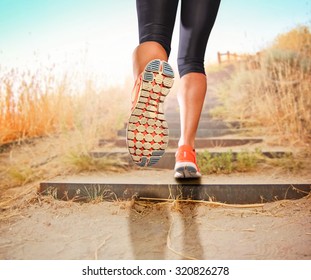  A Woman With An Athletic Pair Of Legs Going For A Jog Or Run During Sunrise Or Sunset Up Stairs In The Mountains - Healthy Lifestyle Concept For Urban Living 