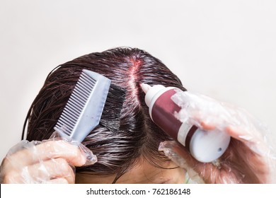 Woman Attempting To Apply Chemical Hair Color Onto Scalp.  Self Help Solution.