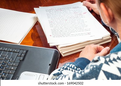 Woman Author Re-writing Her Manuscript After It Has Been Proofread By An Editor.