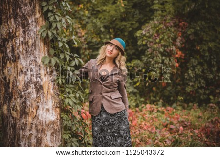 Similar – Blonde woman with hat taking a walk in the forest at sunset with the sun in the background.