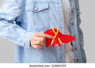 Woman With Awareness Ribbon And Paper Liver On Grey Background. Hepatitis Concept