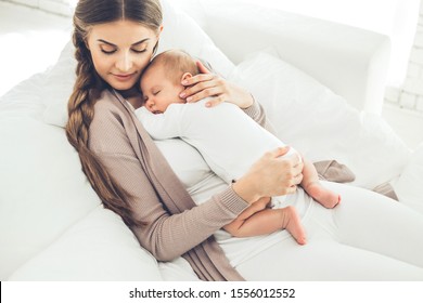 Woman with a baby. Beautiful woman with a small baby at home.