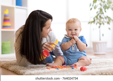 Woman and baby playing musical toys in nursery.
