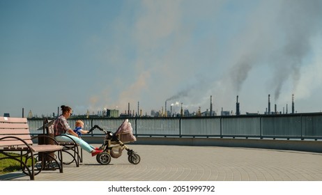 Woman with baby sitting on a bench in a polluted city. environmental pollution and bad ecology in city concept. Ukraine Zaporizhzhia - Shutterstock ID 2051999792