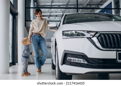 Woman With Baby Son Choosing A Car In A Car Salon