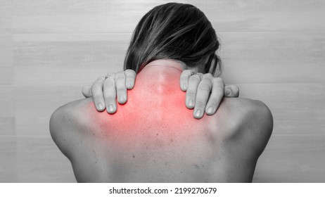 Woman From The Back In Black And White Is Palpating A Red Sore Area On Her Back In The Trapezius. Need For Physical Therapist Or Rehabilitation. Cerbic Problem