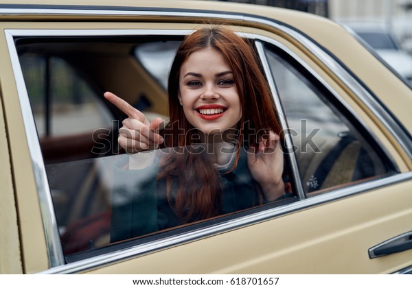        Woman in the back seat of a car in a window \
                      