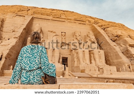 Woman back view looking at The Great Temple of Ramesses II in Abu Simbel Upper Egypt 