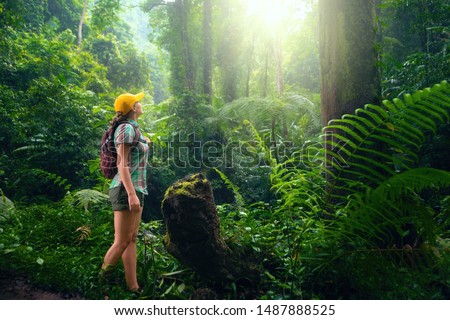 Woman with backpack exploring the beautiful rain forest on the islands of Indonesia.
Travel and ecotourism concept.