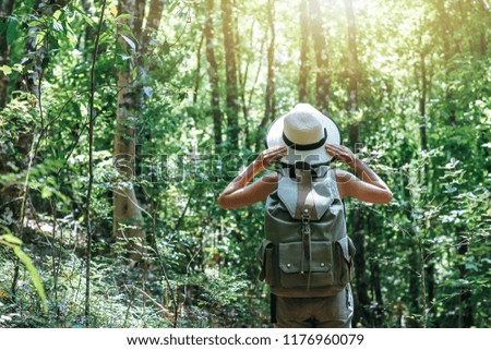 Similar – Hiker woman with backpack raising her arms into the forest