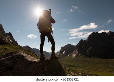 woman with backpack hiking in sunrise mountains  - Shutterstock ID 681352921