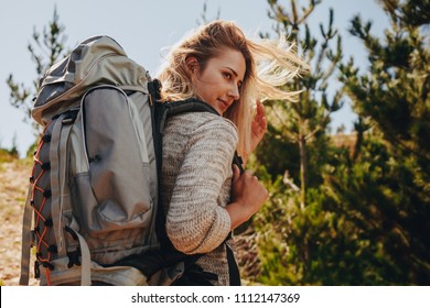 Woman with backpack on hike in nature. Female hiker on mountain trail and looking at a view. - Powered by Shutterstock