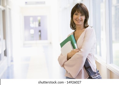 A woman with a backpack standing in a campus corridor - Powered by Shutterstock