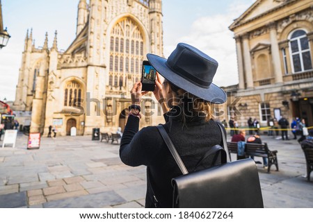 Woman backpack taking picture with smartphone of Bath City UK, United kingdom