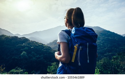 woman backpacker enjoying the view on morning mountain valley