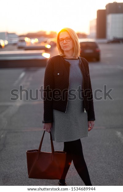 Woman with a bag at the\
parking lot