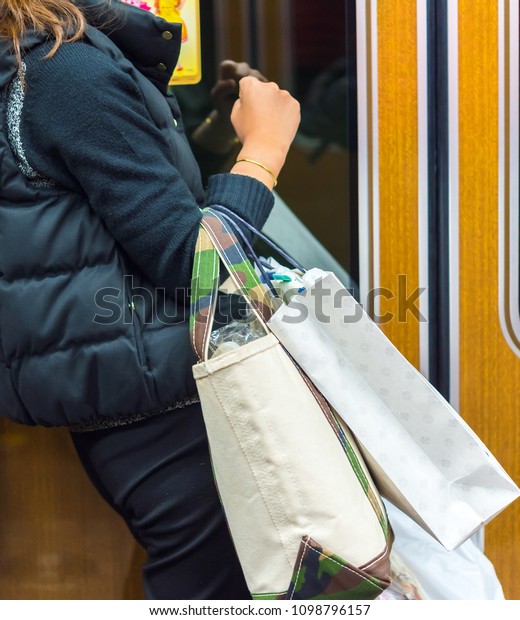 Woman with bags in the subway car, Kyoto, Japan.\
Copy space for text