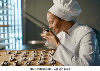 Woman baker enjoying aroma delicious and fresh cookies - Powered by Shutterstock