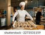 Woman baker preparing sweet buns pastries with sesame seeds