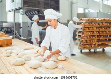 A Woman Baker Smileswith Colleagues At A Bakery.