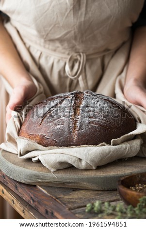 Woman baker's holding hot  sourdough bread closeup