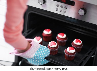 Woman Baking Cupcakes In The Oven