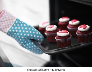 Woman Baking Cupcakes In The Oven