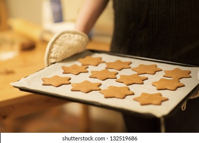 Woman baking ginger bread stars for Christmas. Natural Colors. Real life