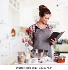 Woman Baking At Home Following Recipe 