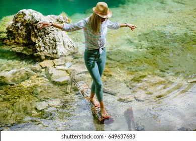 woman balancing on wood log. Blonde woman travel at mountain lake  in Montenegro, Skakavice Oko. - Powered by Shutterstock