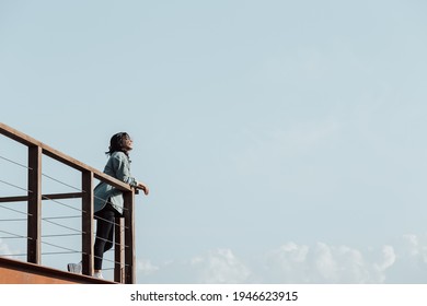 Woman in a balcony over a massive river and the mountains living the moment liberty and freedom concept, wellness during a sunny day - Powered by Shutterstock