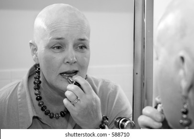 A Woman Bald Due To A Health Issue, Putting On Makeup In The Mirror.