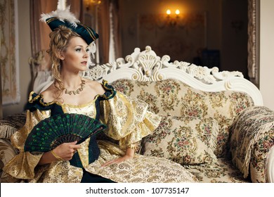 A Woman In A Ball Gown Sits