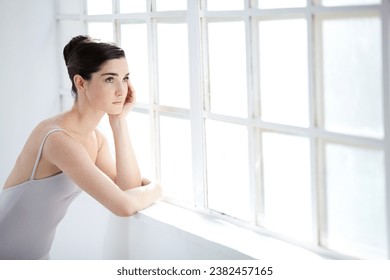 Woman, ballet dancer and thinking at window for future creative, artistic vision or passion goals. Female person, elegant costume and idea thoughts for hair bun dreaming, career or performance plan