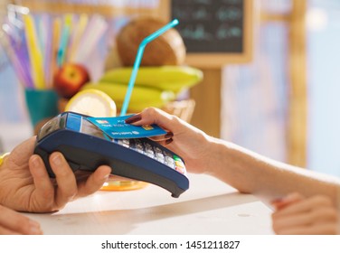 Woman At The Bar Paying Using A Contactless Credit Card, She Is Leaning It On The POS Teminal, Payments And Technology Concept