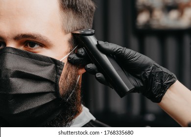 Woman Barber Cutting Hair To A Bearded Man In Face Mask. Quarantine Haircut Concept.