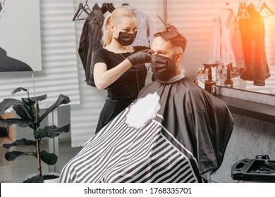 Woman Barber Cutting Hair To A Bearded Man In Face Mask. Quarantine Haircut Concept.