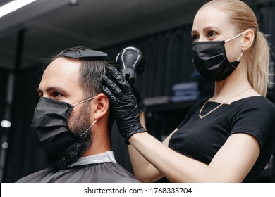 Woman Barber Cutting Hair To A Bearded Man In Face Mask. Quarantine Haircut Concept.