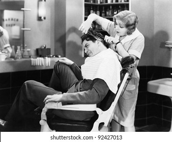 Woman barber cutting a man's hair