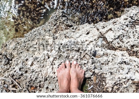 Woman bare feet stand on stone, view from top