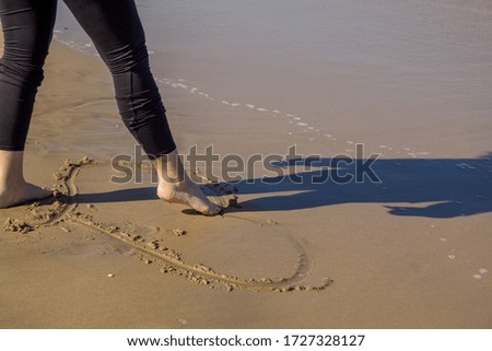 woman with bare feet walking on the beach