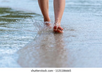 Woman bare foot walking on the summer beach. close up leg of young woman walking along wave of sea water and sand on the beach. Travel Concept. - Powered by Shutterstock