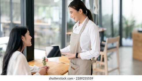 Woman barista talking with customer about coffee drink menu with happy emotion at cafe.coffee shop business owner concept,Service mind waiter. - Powered by Shutterstock