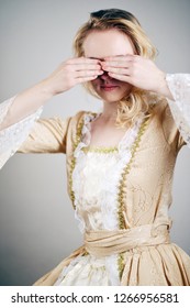 Woman In A Baroque Dress Hiding Her Eyes