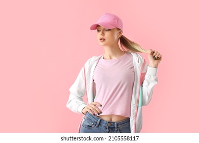 Woman In Baseball Cap Touching Hair On Pink Background