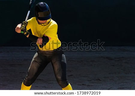 A Woman Baseball Player is at Bat Getting ready for the Pitch